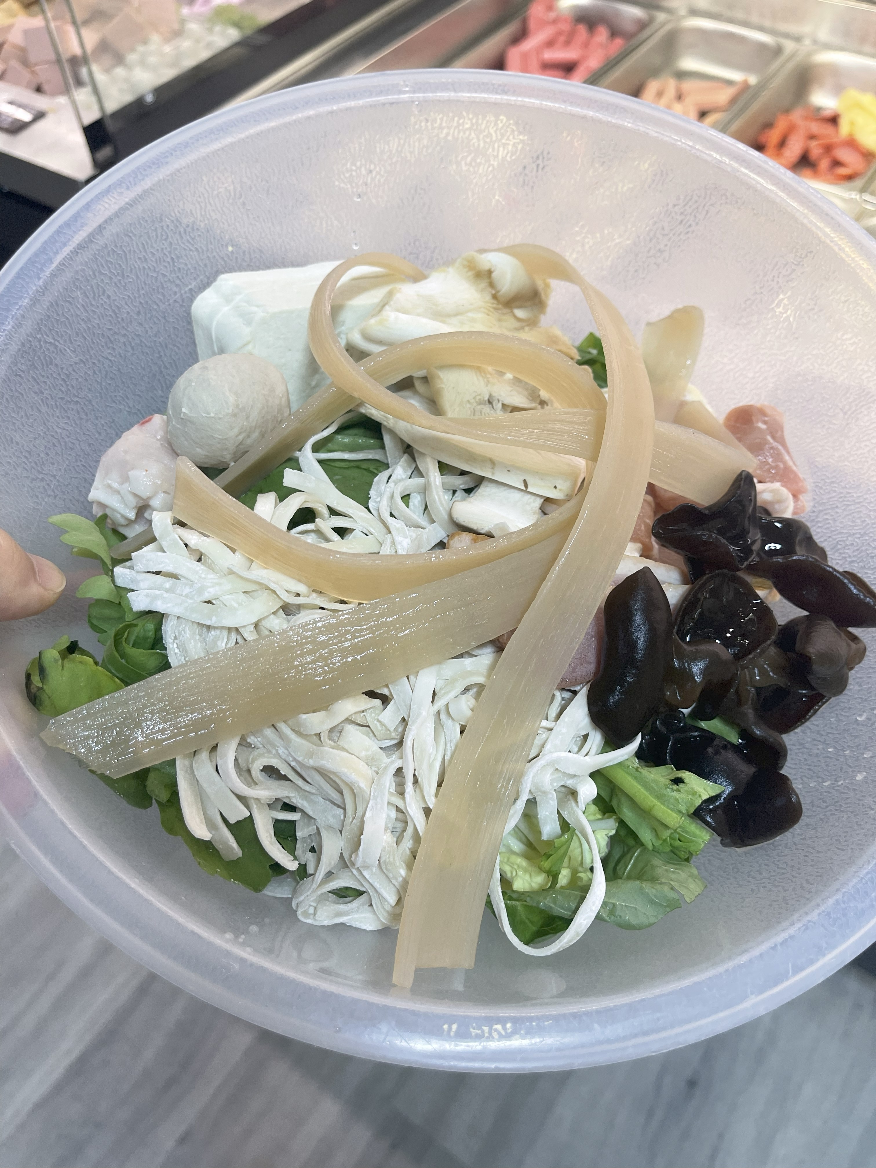 A bowl filled with assorted ingredients before weighing at the counter